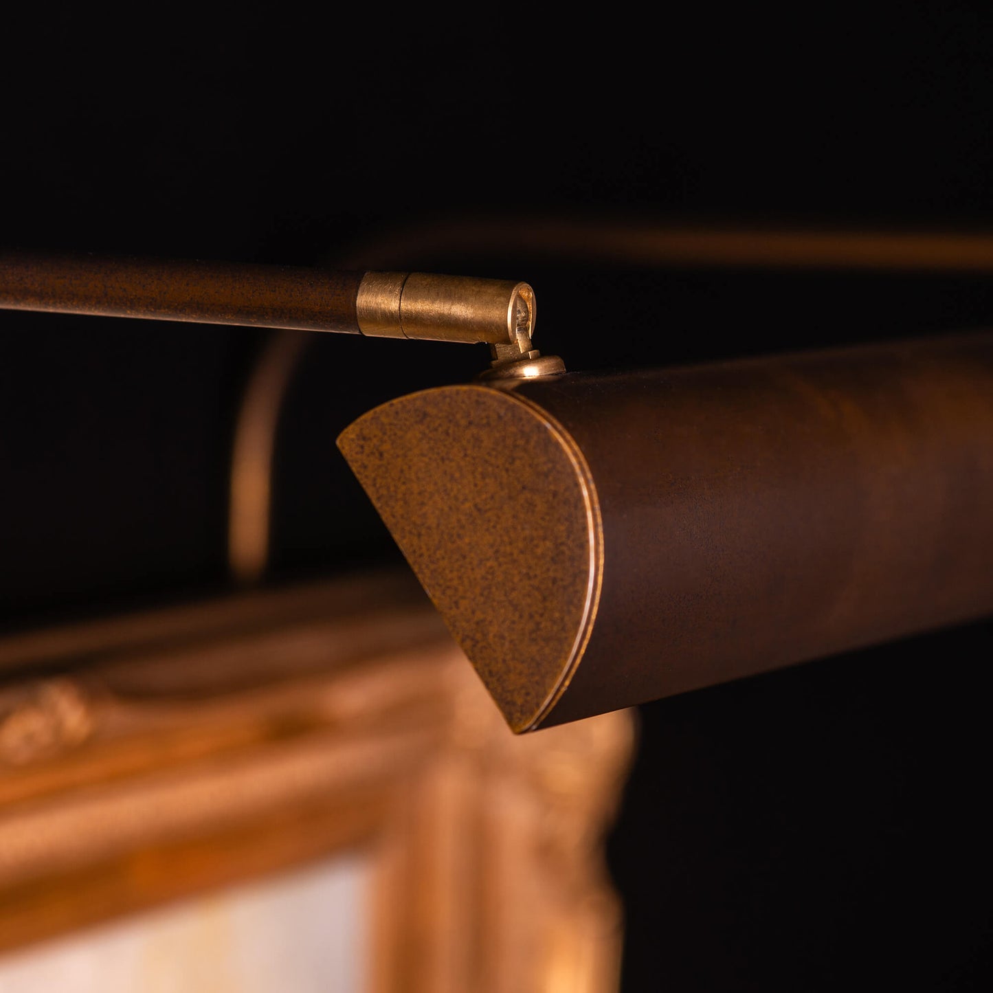 Close up an ArtView II picture light in a bronze finish focused on the picture head