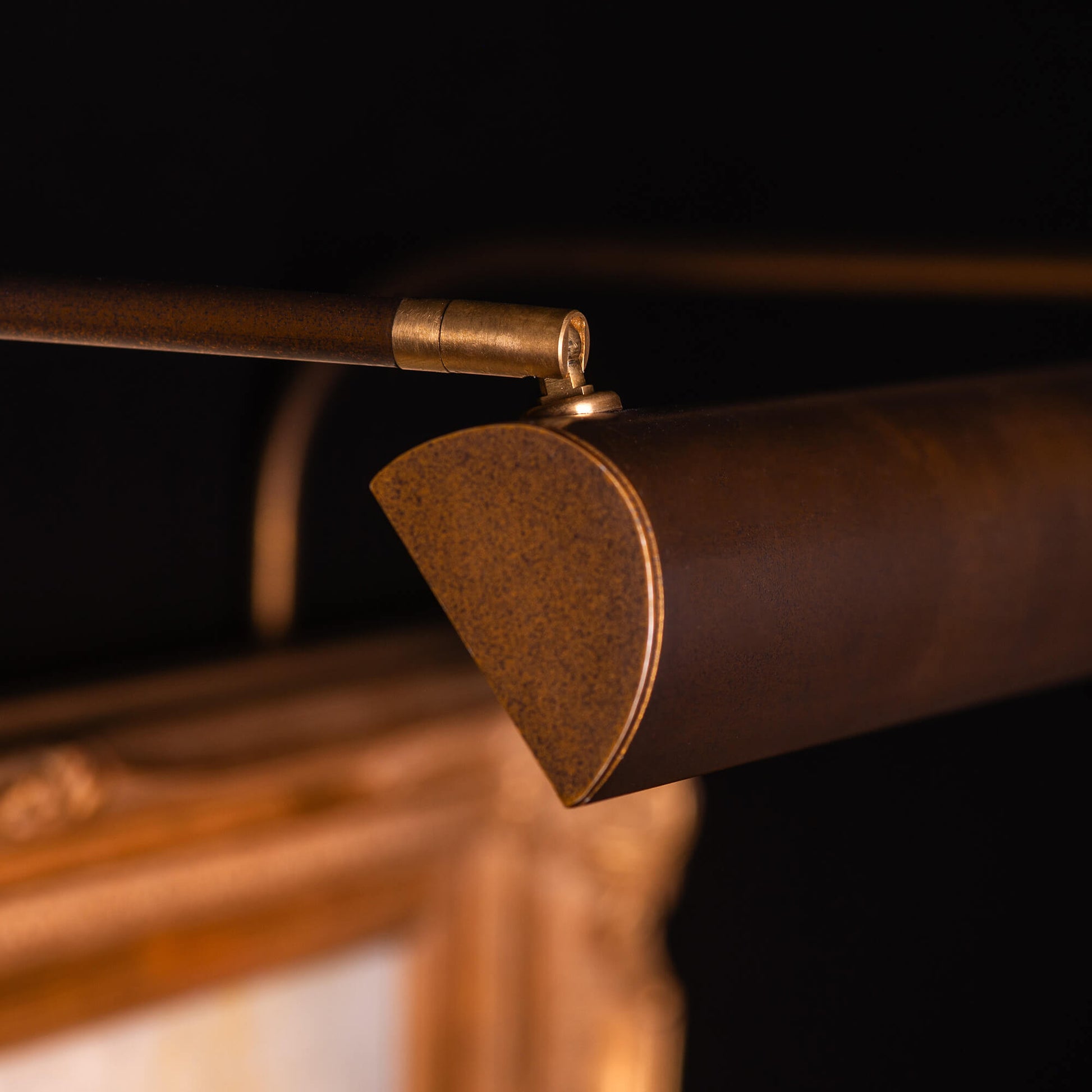 Close up an ArtView II picture light in a bronze finish focused on the picture head