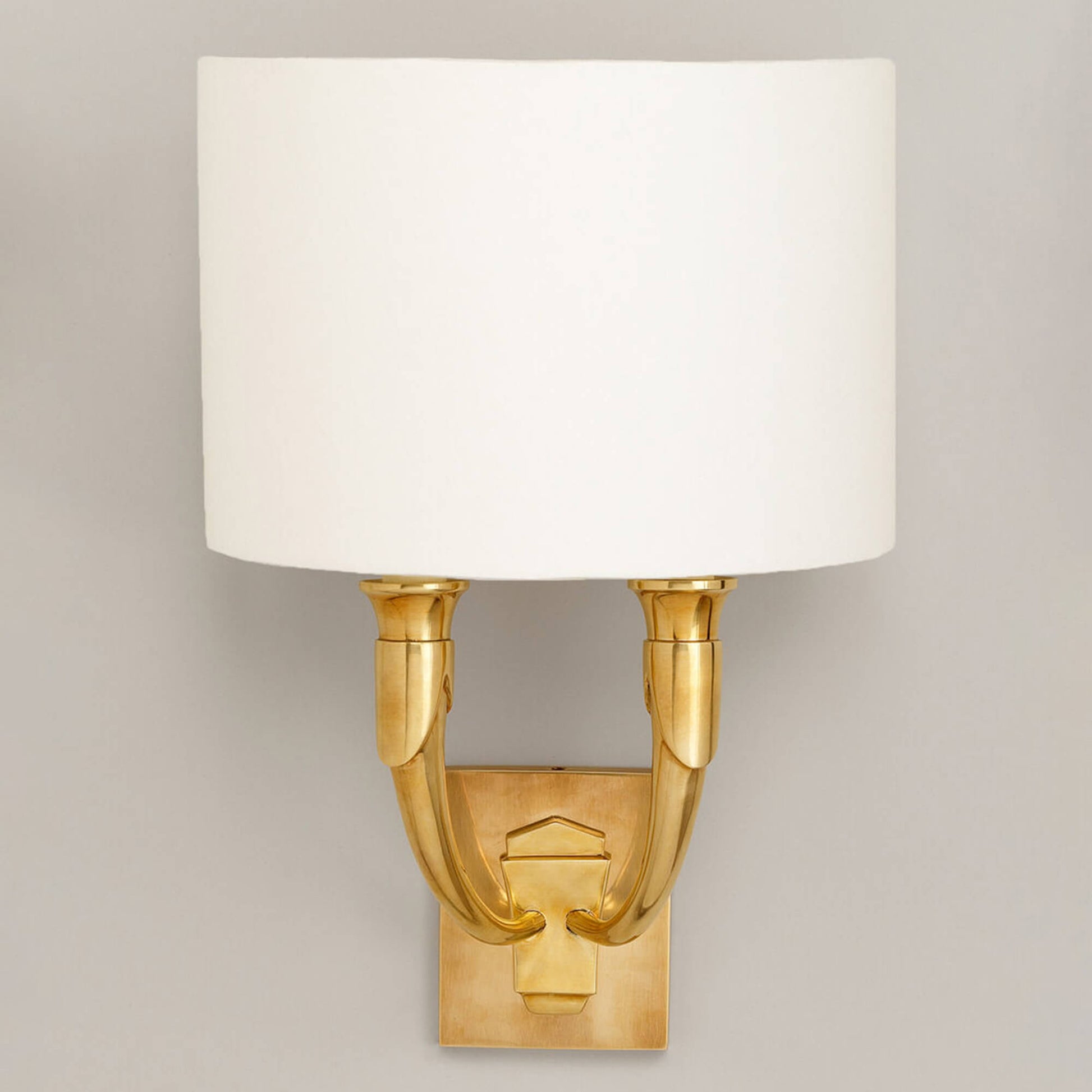 French horn wall light with large back plate in brass with lily linen shade